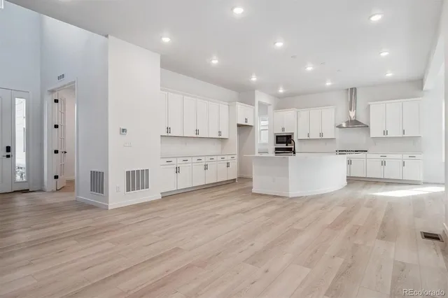 a large kitchen with cabinets and wooden floor