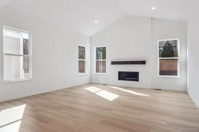 a view of an empty room with window and fire place