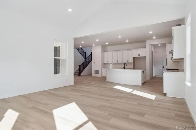 a view of a kitchen with wooden floor and a sink