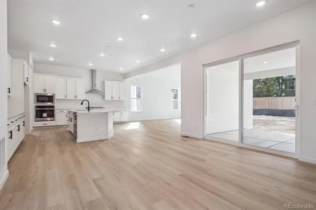 a large kitchen with stainless steel appliances kitchen island a large counter top and a stove top oven