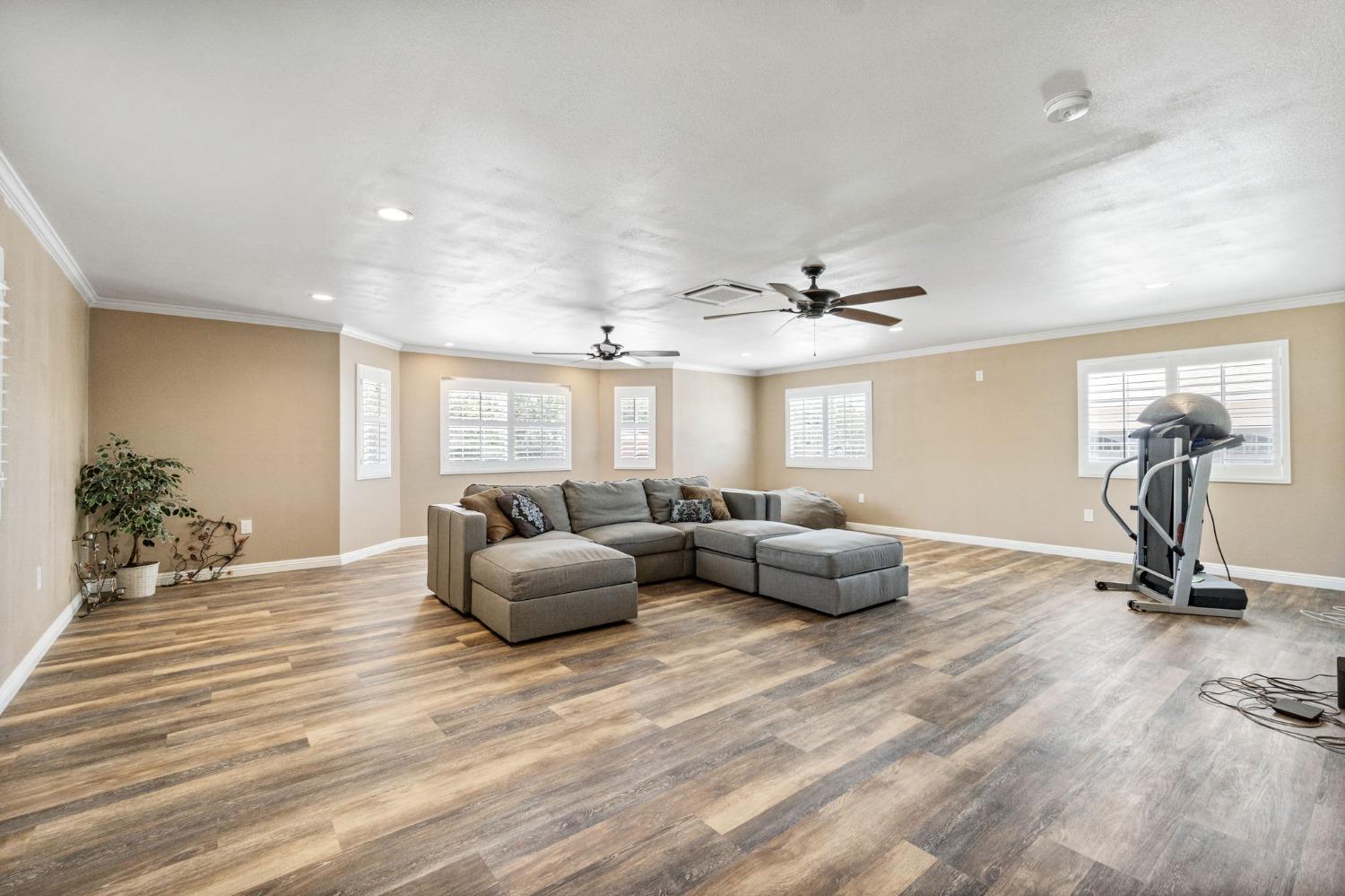 16972 Monreal Road Madera, CA 93636 - Photo 16 of 34 a living room with furniture gym equipment and a window