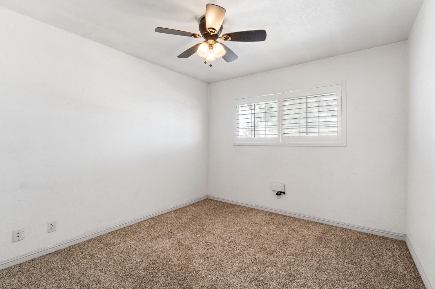 16972 Monreal Road Madera, CA 93636 - Photo 17 of 34 an empty room with windows and fan