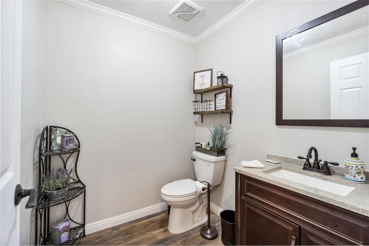 16972 Monreal Road Madera, CA 93636 - Photo 19 of 34 a bathroom with a toilet a sink and mirror