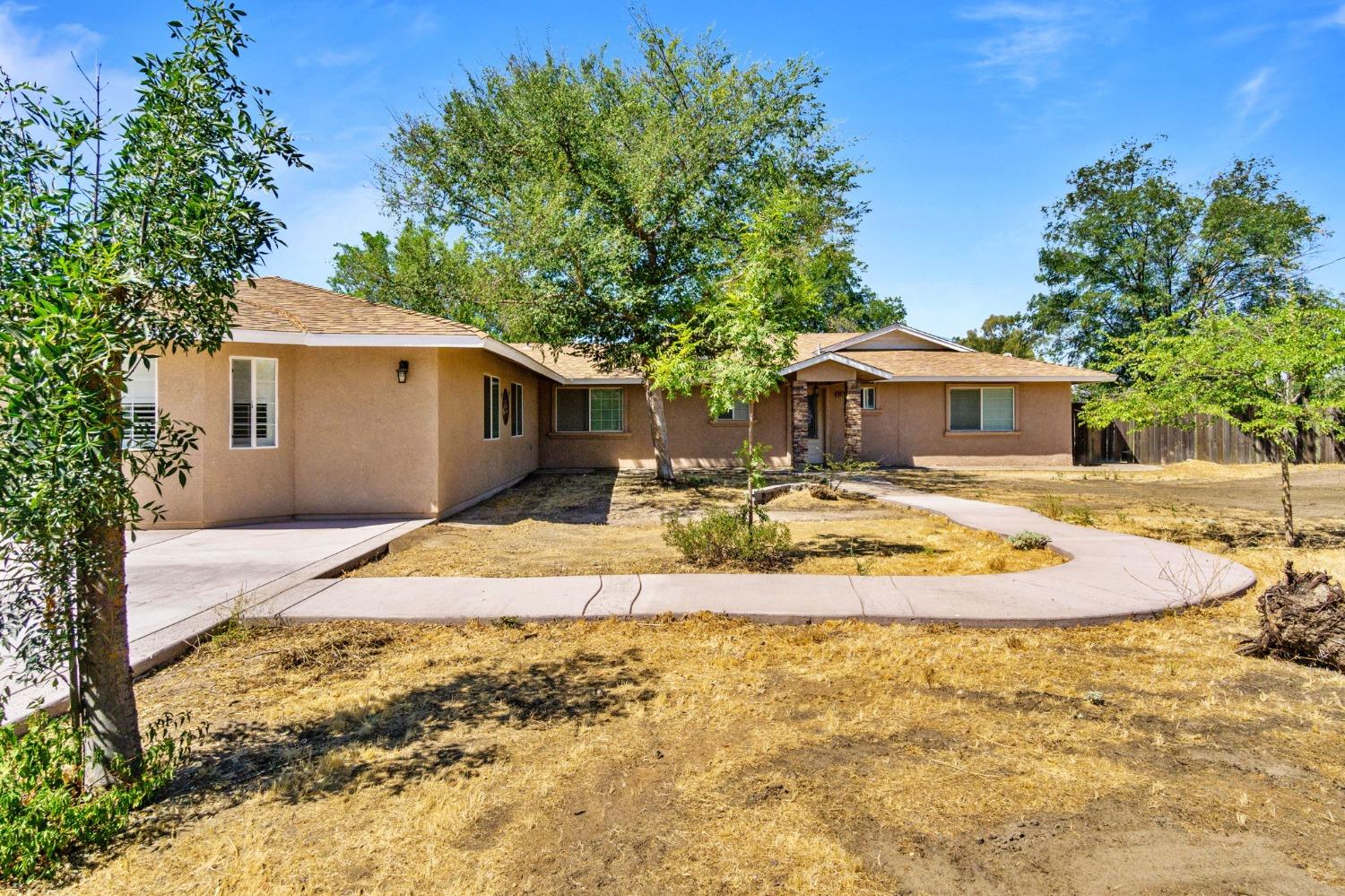 16972 Monreal Road Madera, CA 93636 - Photo 32 of 34 a view of a house with basketball space and tree s