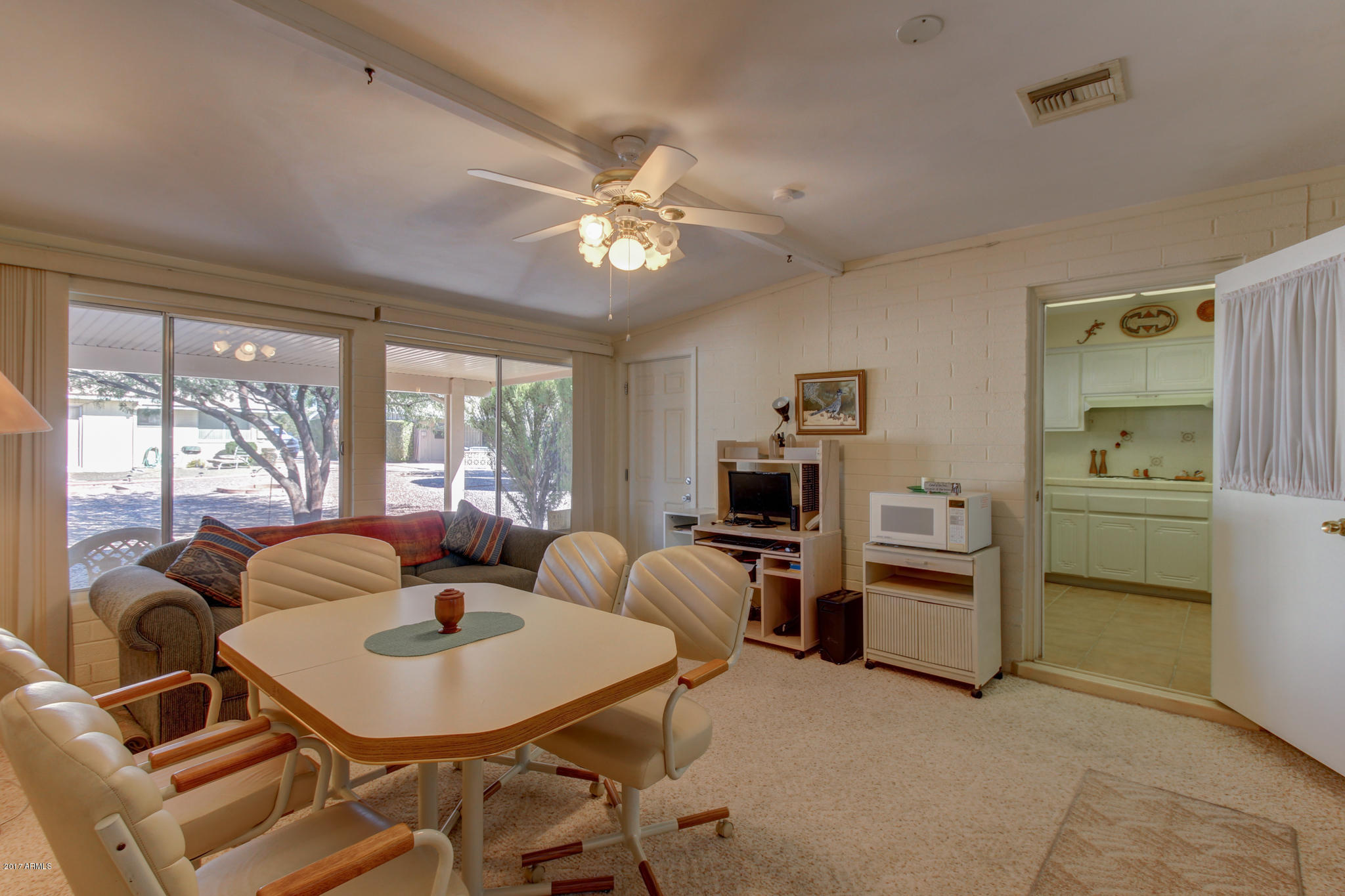 10008 West Riviera Drive Sun City, AZ 85351 - Photo 3 of 26 a living room with furniture two window and a flat screen tv