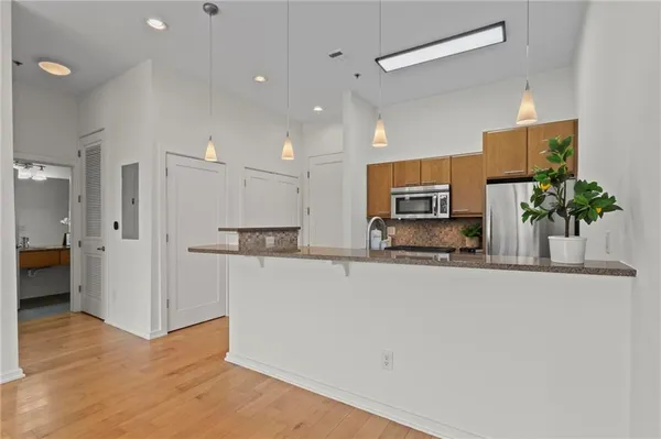 a view of a kitchen with stainless steel appliances a refrigerator and a counter top space