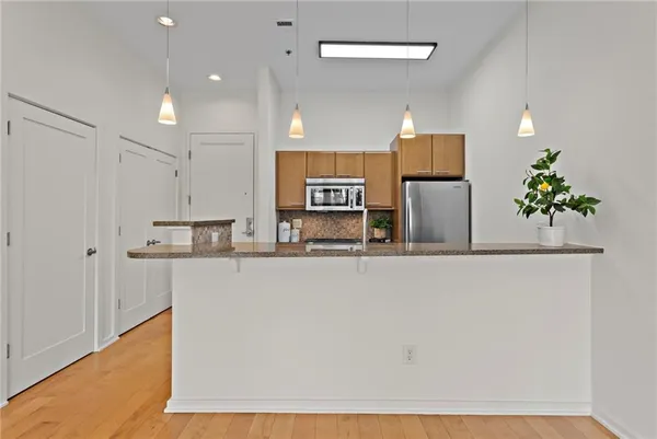 a kitchen with stainless steel appliances a refrigerator and microwave