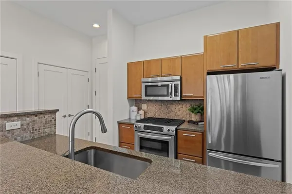 a kitchen with stainless steel appliances a refrigerator stove and microwave