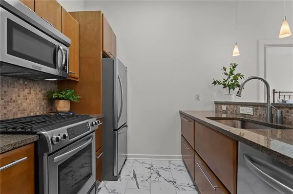 a kitchen with stainless steel appliances a sink a stove cabinets and a microwave