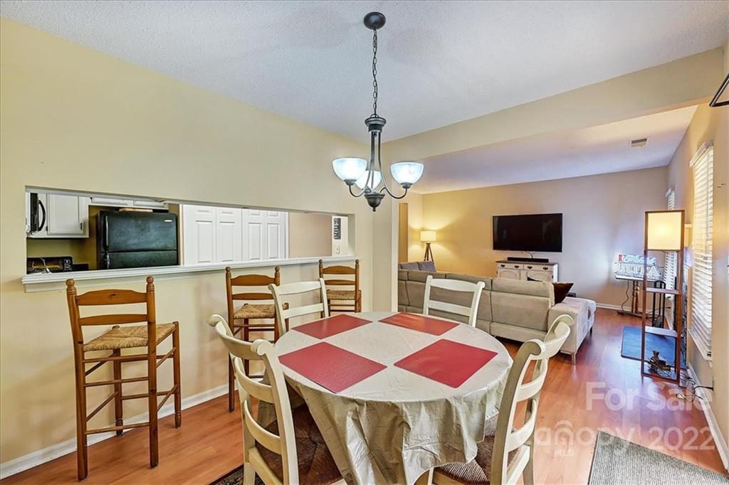 19843 Henderson Road, Unit B Cornelius, NC 28031 - Photo 14 of 43 a view of a dining room with furniture and wooden floor