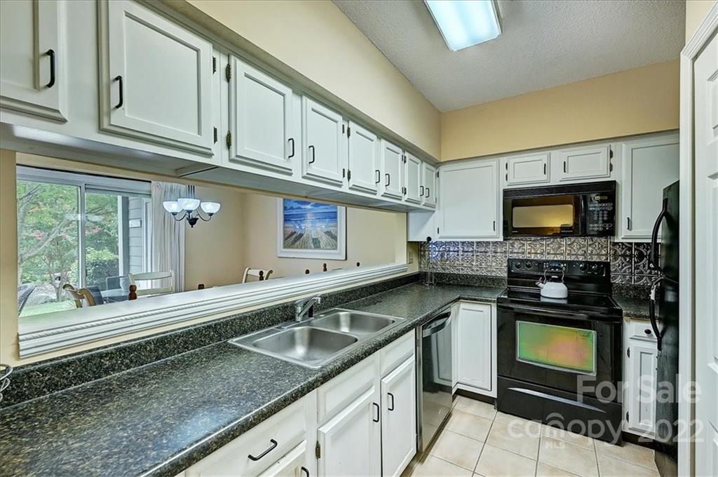 19843 Henderson Road, Unit B Cornelius, NC 28031 - Photo 16 of 43 a kitchen with stainless steel appliances granite countertop a stove a sink and a microwave