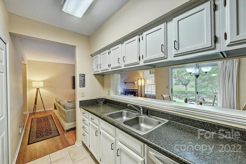 19843 Henderson Road, Unit B Cornelius, NC 28031 - Photo 17 of 43 a kitchen with granite countertop a sink and a stove next to a window