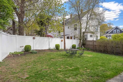 a backyard of a house with table and chairs
