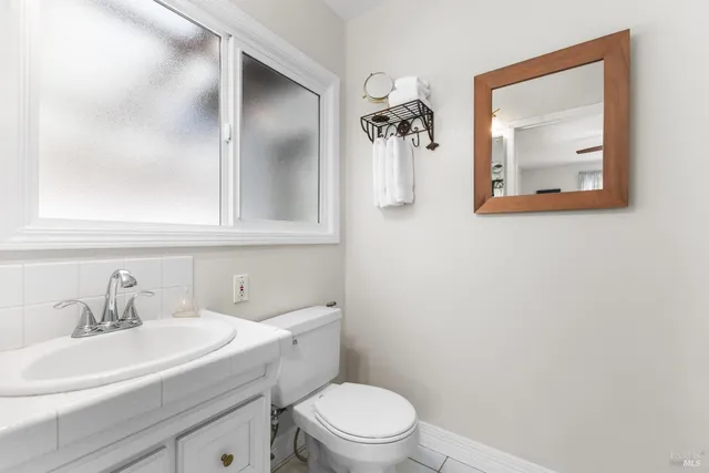 a bathroom with a toilet sink and mirror