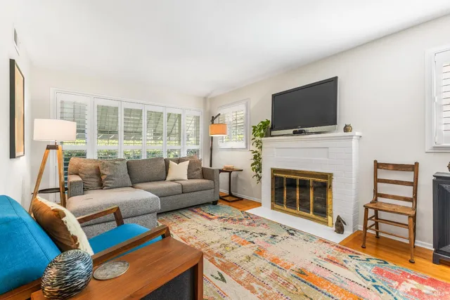 a living room with furniture a flat screen tv and a fireplace
