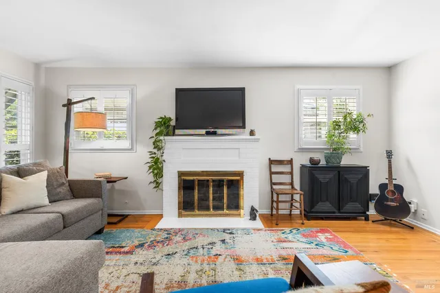 a living room with furniture a flat screen tv and a fireplace
