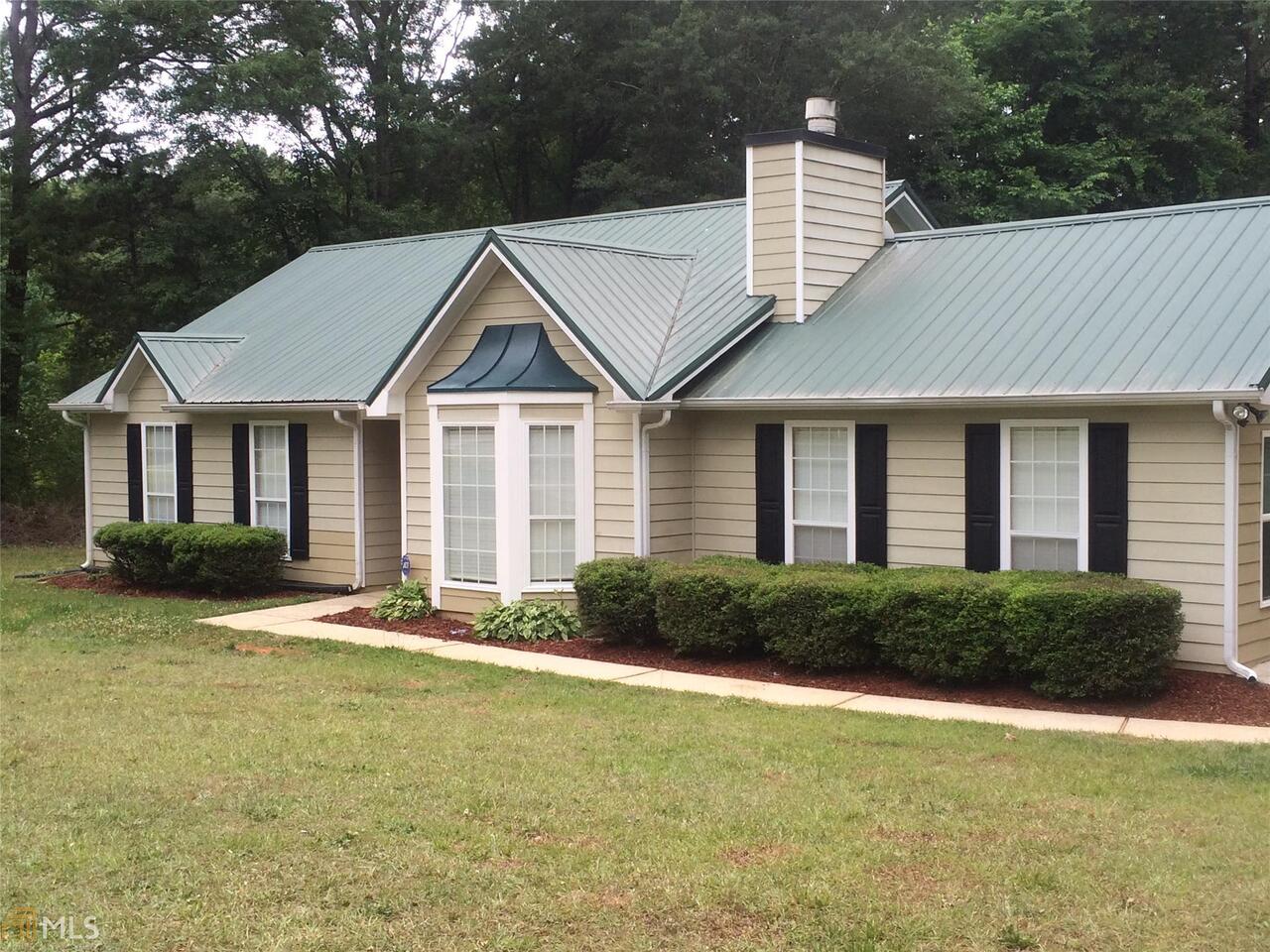 30 Standing Rock Road, Unit 9 Senoia, GA 30276 - Photo 1 of 1 a house with a garden and large trees