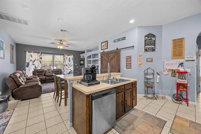 a view of living room kitchen with stainless steel appliances granite countertop furniture and a view of living room