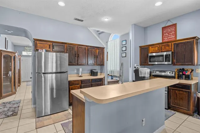 a kitchen with stainless steel appliances a refrigerator sink and microwave