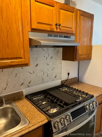a stove top oven sitting inside of a kitchen