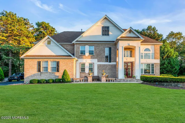 a front view of a house with a yard and trees