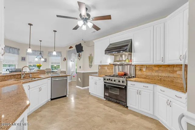 a kitchen with stainless steel appliances kitchen island granite countertop a sink a counter top space and cabinets