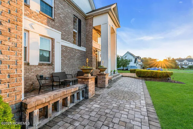 a view of a patio with table and chairs potted plants and a palm tree