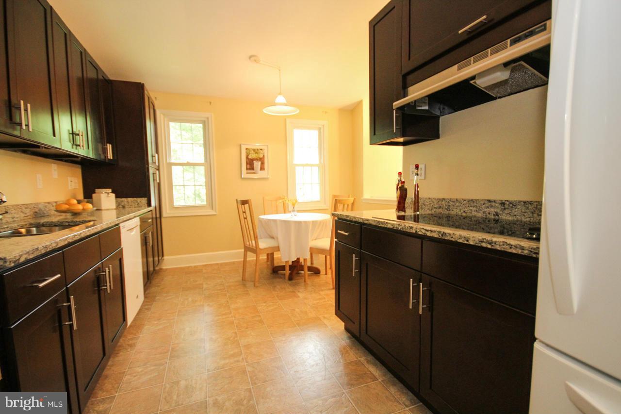 14305 Piccadilly Road Silver Spring, MD 20906 - Photo 11 of 30 a kitchen with a sink dining table and chairs