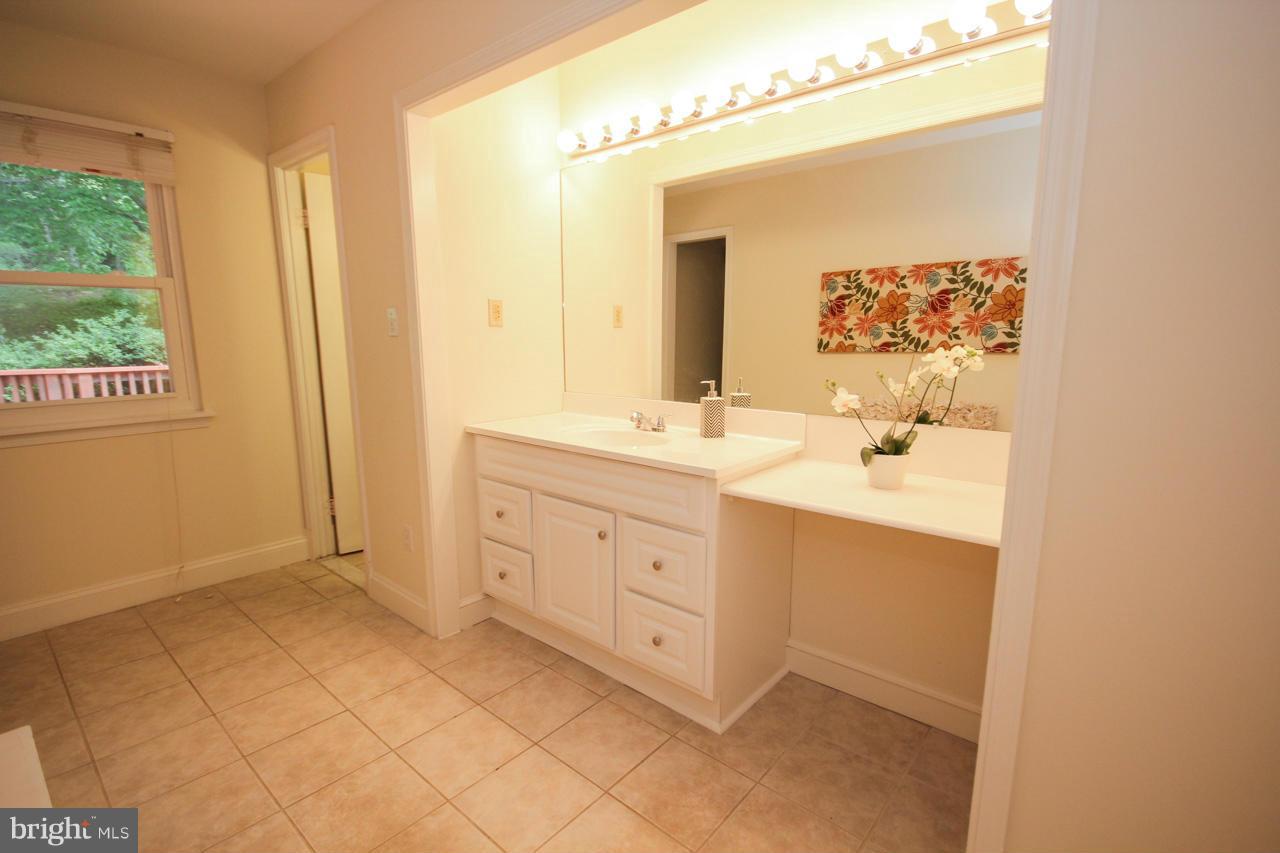 14305 Piccadilly Road Silver Spring, MD 20906 - Photo 22 of 30 a spacious bathroom with a double vanity sink a mirror and a shower