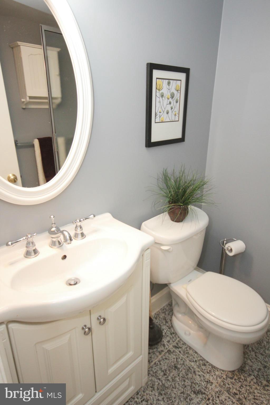 14305 Piccadilly Road Silver Spring, MD 20906 - Photo 26 of 30 a bathroom with a toilet a sink and mirror