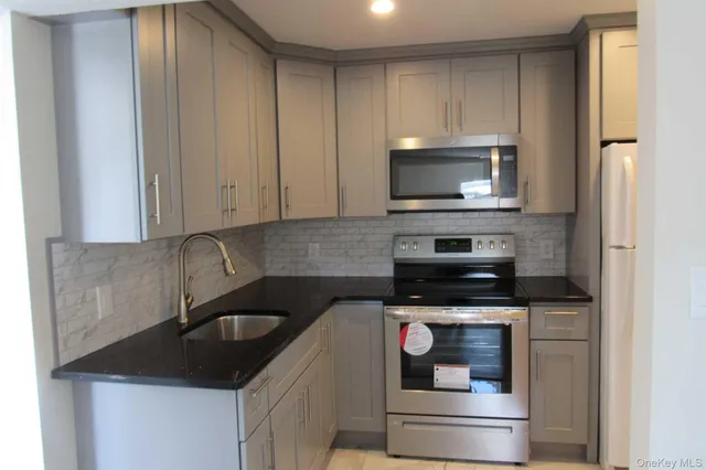 a kitchen with granite countertop white cabinets and stainless steel appliances