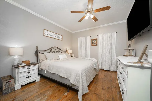 a bedroom with a bed and a flat tv screen on dresser