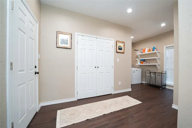 a view of a hallway with wooden floor and closet