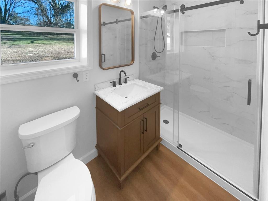 314 Jackson Street Cartersville, GA 30120 - Photo 14 of 18 a bathroom with a toilet sink and mirror
