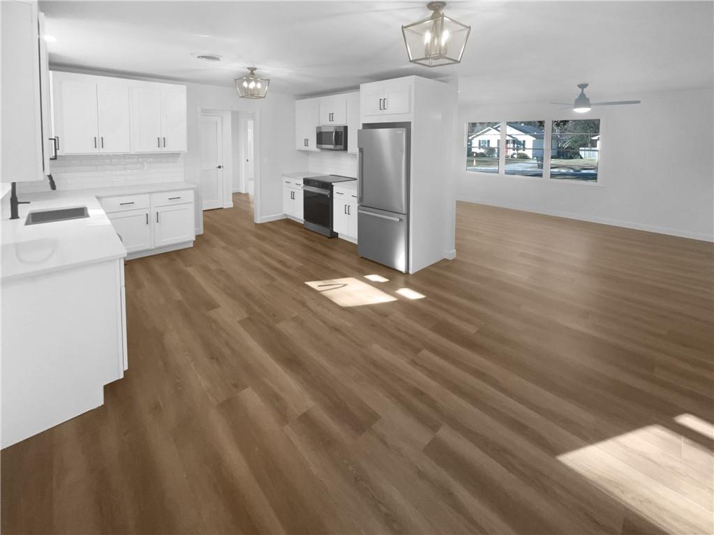 314 Jackson Street Cartersville, GA 30120 - Photo 2 of 18 a kitchen with stainless steel appliances wooden floors and white cabinets