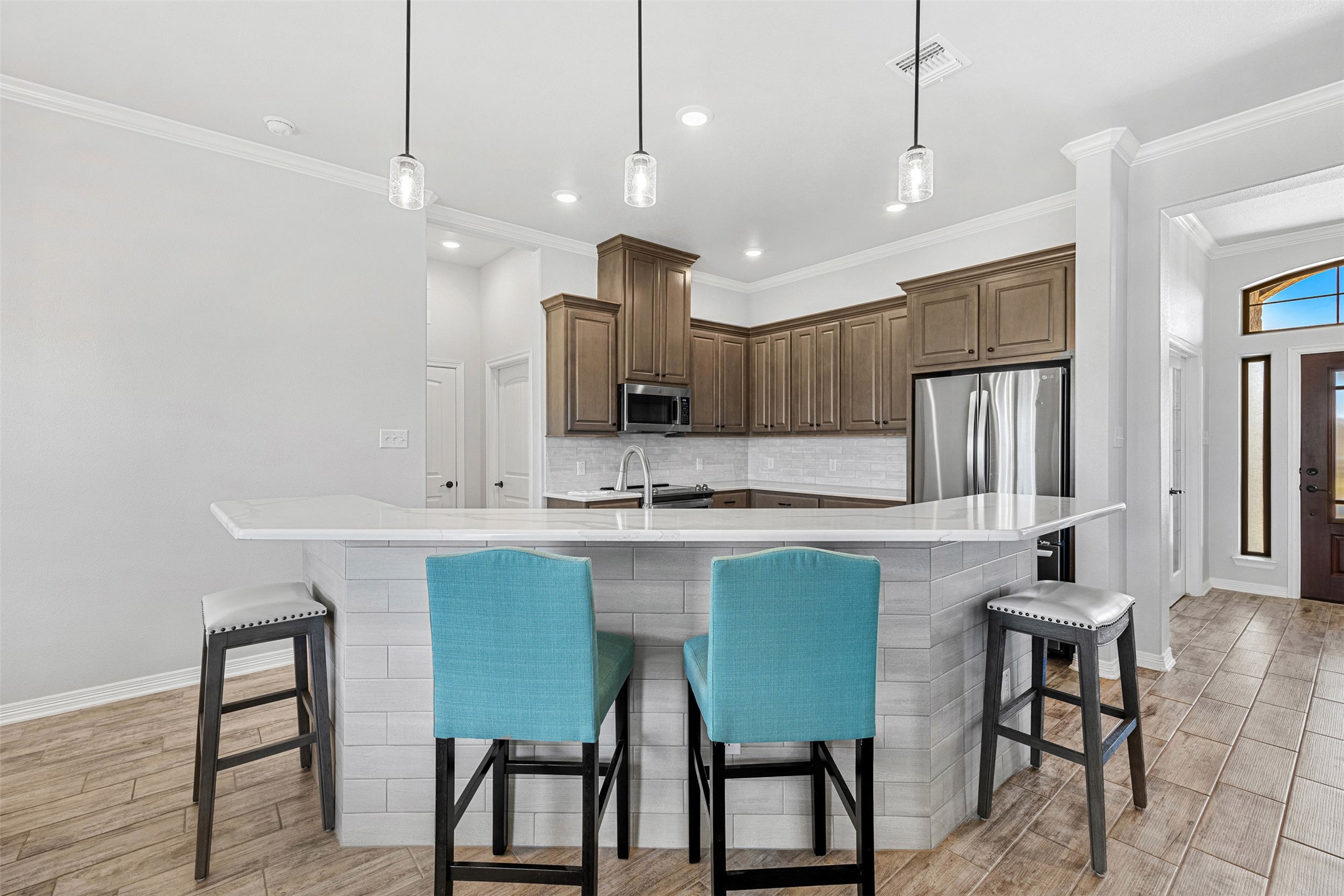 5513 Hollow Loop Salado, TX 76571 - Photo 11 of 36 a kitchen with kitchen island granite countertop a table chairs refrigerator and microwave
