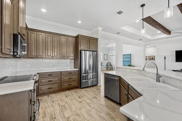a kitchen with granite countertop a sink stainless steel appliances and cabinets