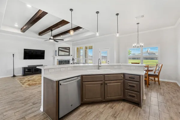 a kitchen with stainless steel appliances granite countertop a sink a stove and a wooden floors