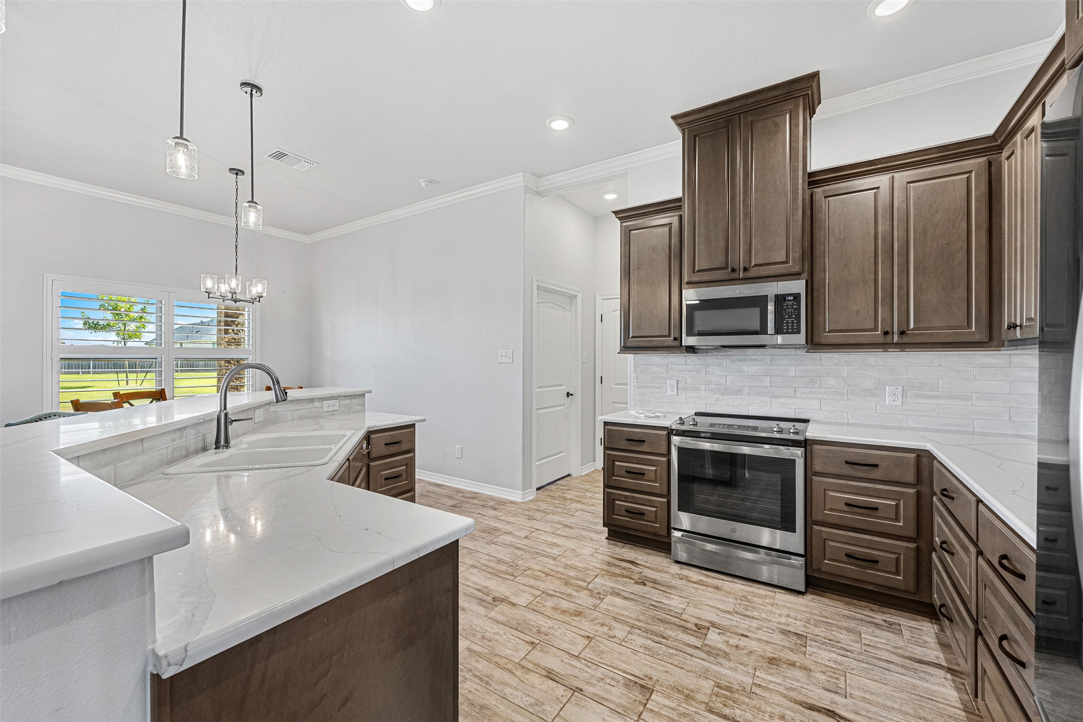 5513 Hollow Loop Salado, TX 76571 - Photo 14 of 36 a kitchen with stainless steel appliances kitchen island granite countertop a sink and a stove top oven with wooden floor