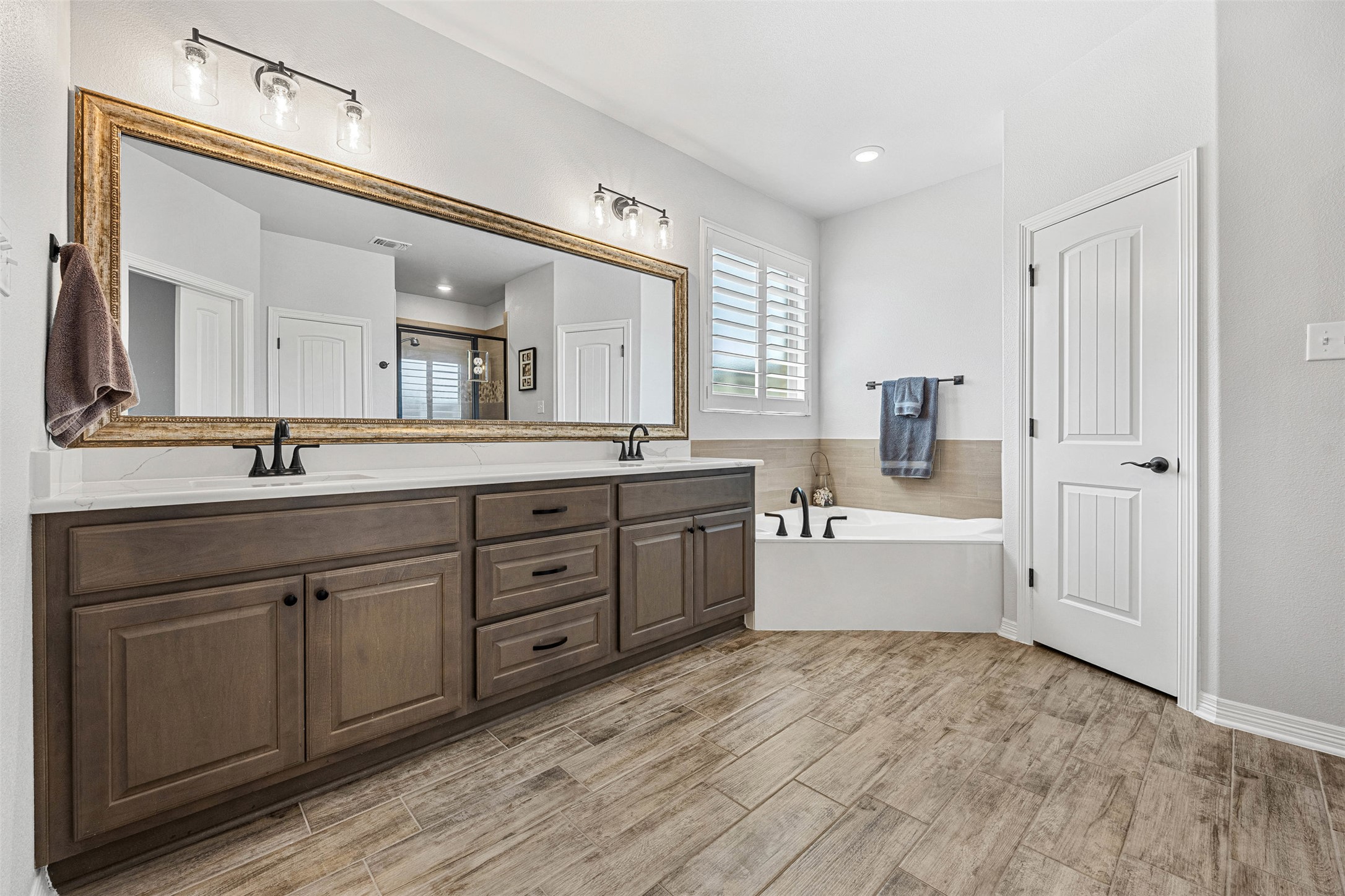 5513 Hollow Loop Salado, TX 76571 - Photo 22 of 36 a large white bathroom with a double vanity sink a mirror and a bathtub