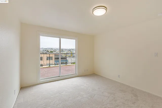 a view of a hallway with wooden floor and a bathroom