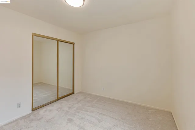 an empty room with closet and mirror