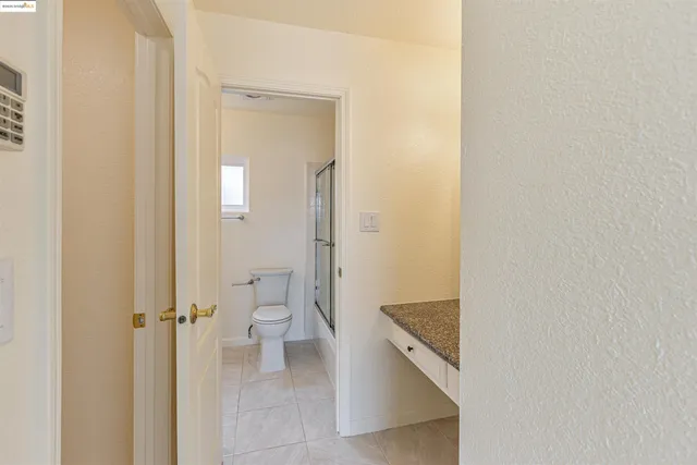a bathroom with a granite countertop toilet and a shower