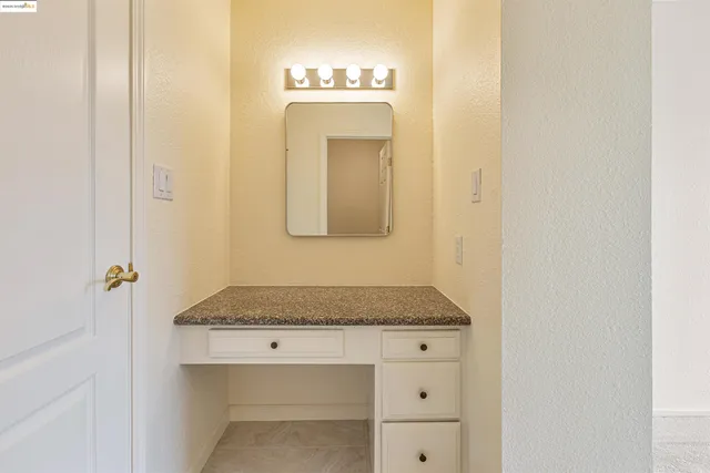 a bathroom with a granite countertop sink and a mirror