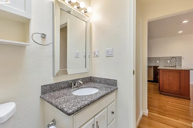 a bathroom with a granite countertop sink and a mirror