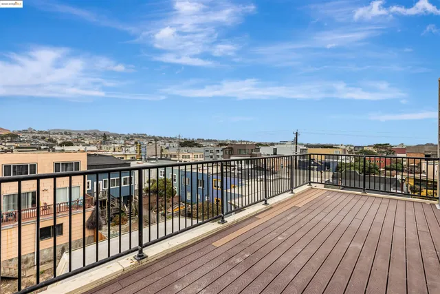 a view of roof deck with wooden floor and city view