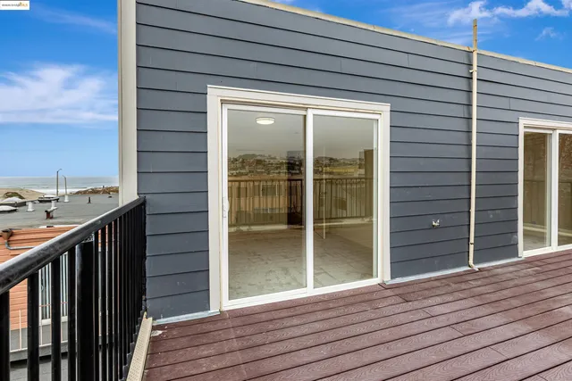 a view of a balcony with wooden floor and sink