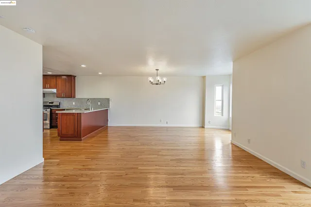 a view of kitchen and kitchen with granite countertop wooden floor