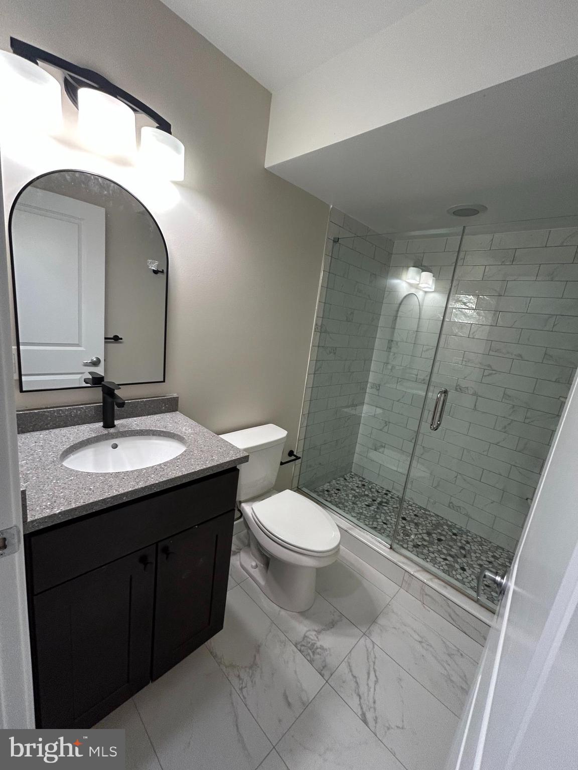 2542 Ellsworth Street, Unit A Philadelphia, PA 19146 - Photo 18 of 21 a bathroom with a toilet a sink and mirror