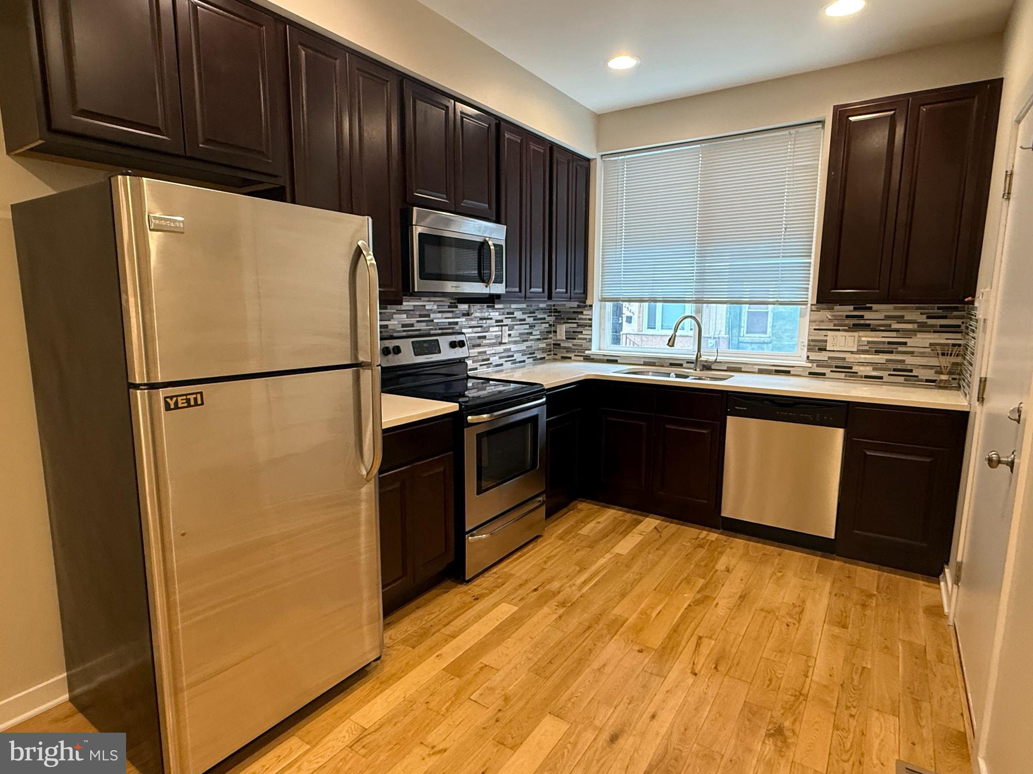 2542 Ellsworth Street, Unit A Philadelphia, PA 19146 - Photo 5 of 21 a kitchen with stainless steel appliances granite countertop a stove a refrigerator and a sink